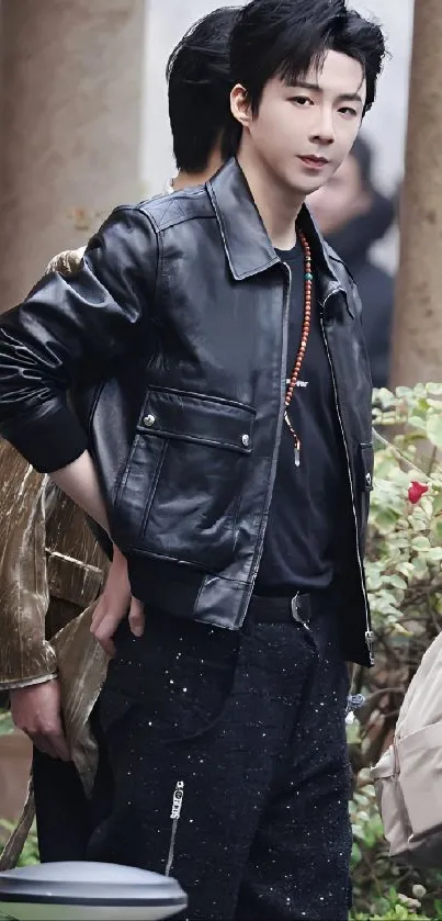 Person in a stylish black leather jacket, outdoors with a chic urban look.