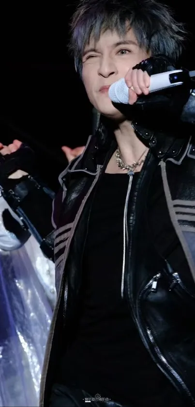 Person on stage in black leather jacket.