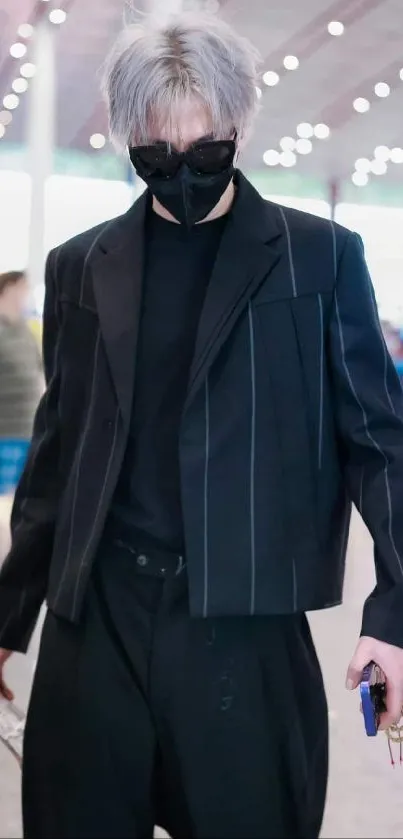 Person in a sleek black outfit with white hair in a modern setting.