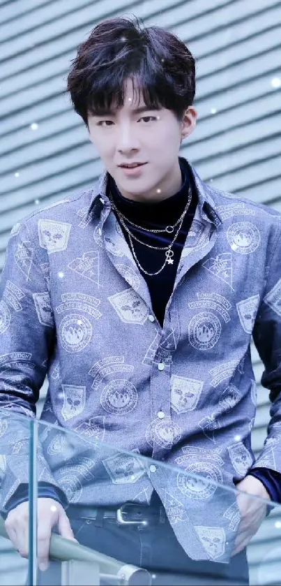 Man in stylish blue patterned shirt with modern design background.