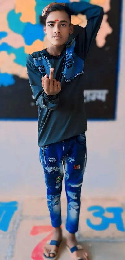 Young man in stylish blue jeans standing against colorful wall.