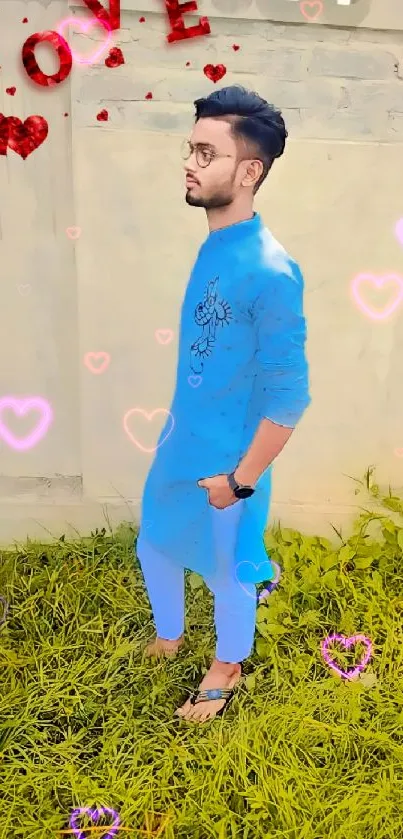 Stylish man in blue kurta with love symbols on grass.