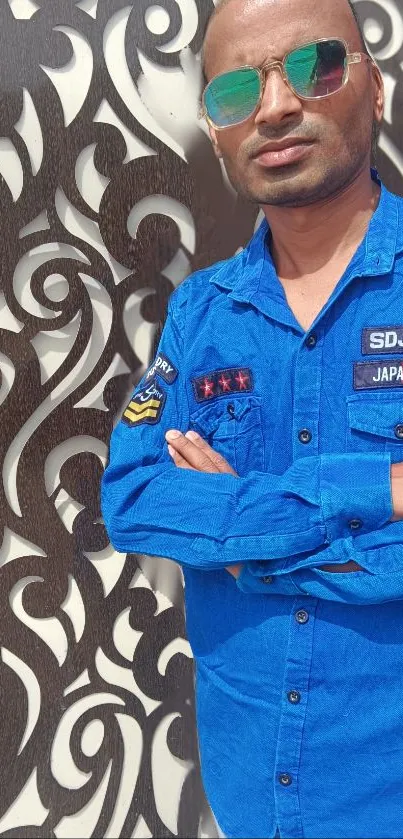 Portrait of man in blue shirt with artistic background pattern.