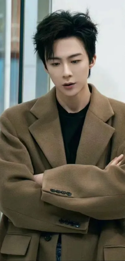 Chic man in a brown coat posing elegantly.