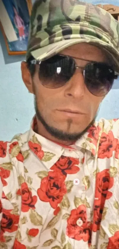 Portrait with camo hat and floral shirt, inside a room.