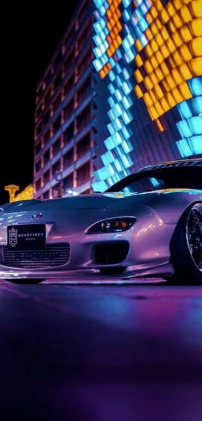 A sleek car parked under vibrant city lights at night.