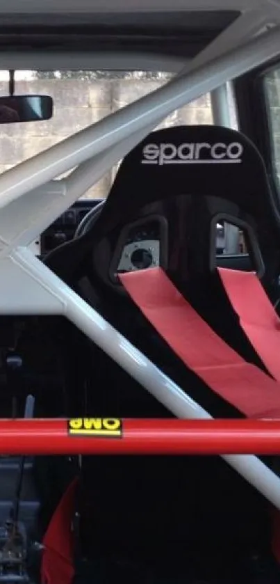 Racing car interior with Sparco seat and red seatbelts.