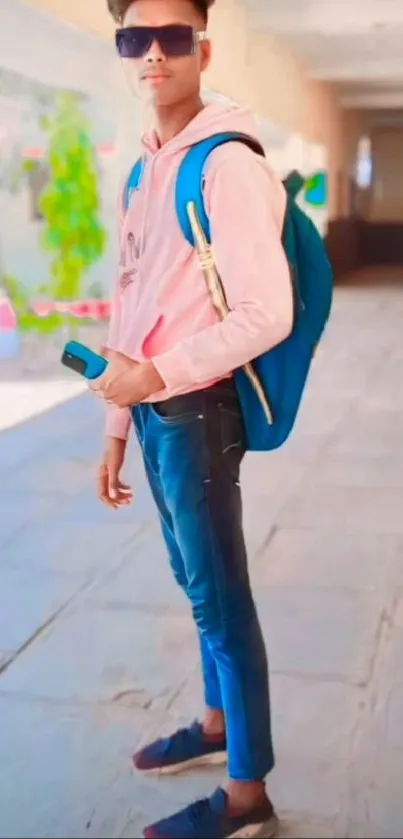 Person in stylish casual outfit with a blue backpack outdoors.