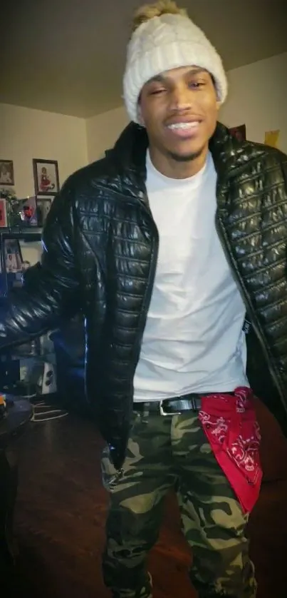 Person in beanie, leather jacket, and camo pants in a stylish pose.