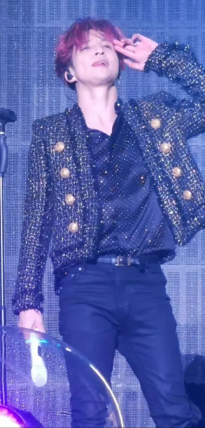 Performer in a sparkling jacket striking a pose on stage.