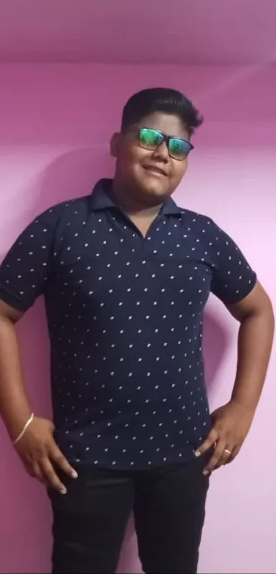 Fashionable young man posing against pink background.