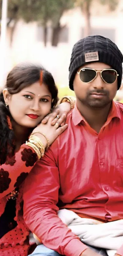 Couple in stylish red outfits posing outdoors.