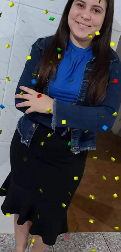 Woman in denim jacket and blue blouse standing indoors.