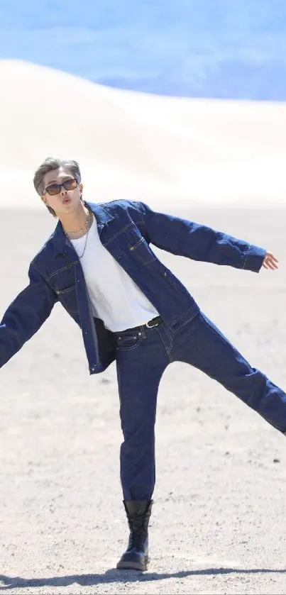 Denim-clad figure posing in the desert showcasing style.