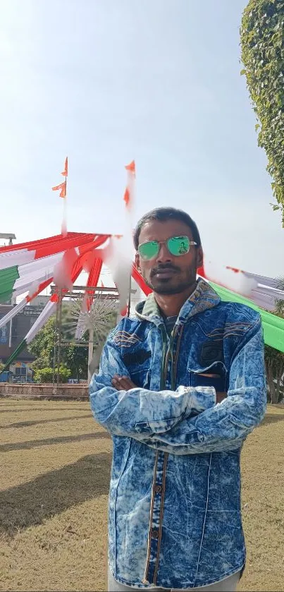 Person in denim jacket standing outdoors with colorful decorations.