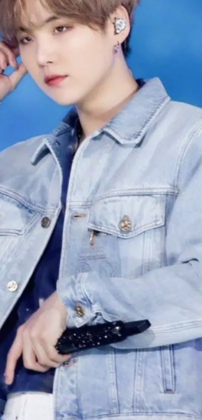 A person in a denim jacket against a vibrant blue background.