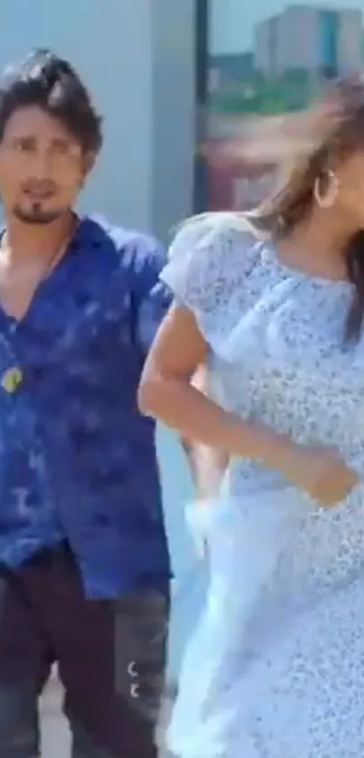 Stylish couple in blue attire enjoying a city backdrop.