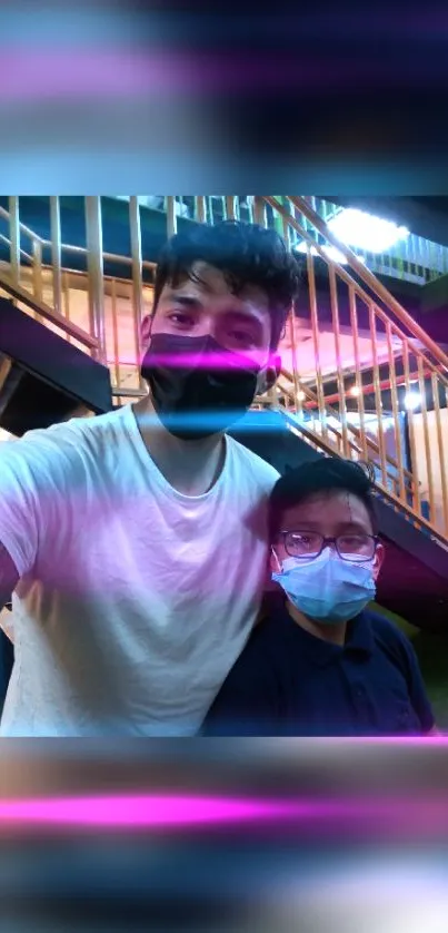 Two friends with masks, neon pink glow, bright staircase background.