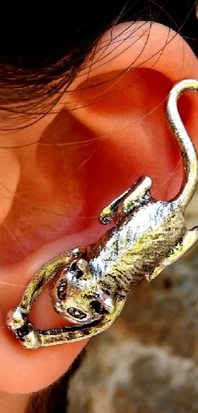 Monkey-shaped ear cuff hugging an ear with textured background.