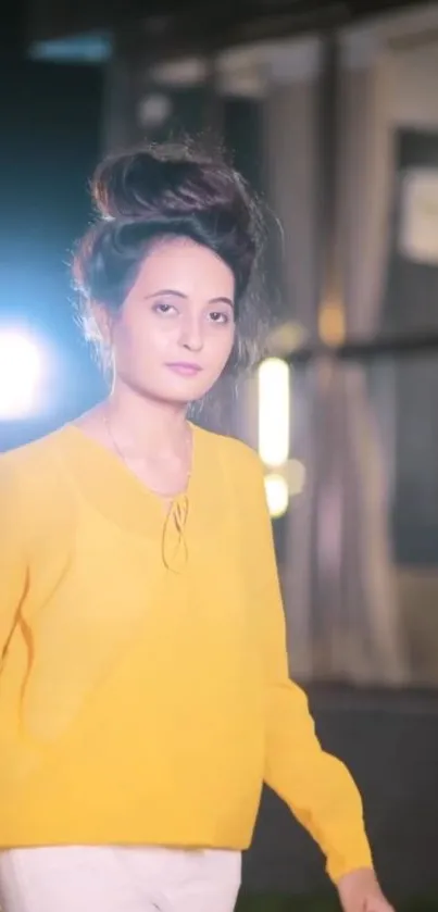 Woman in yellow with urban night backdrop.