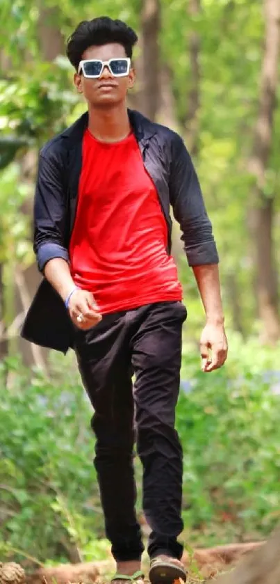 Person walking in a vibrant green forest, wearing stylish red and black clothing.