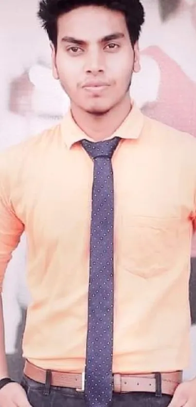 Man in orange shirt with blue tie, stylish formal look.