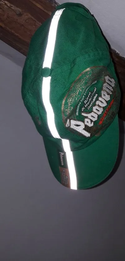 Green cap with reflective strip on wooden beam.