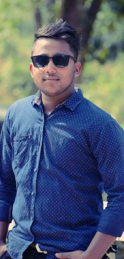 Young man wearing sunglasses in outdoor setting, showcasing fashion.