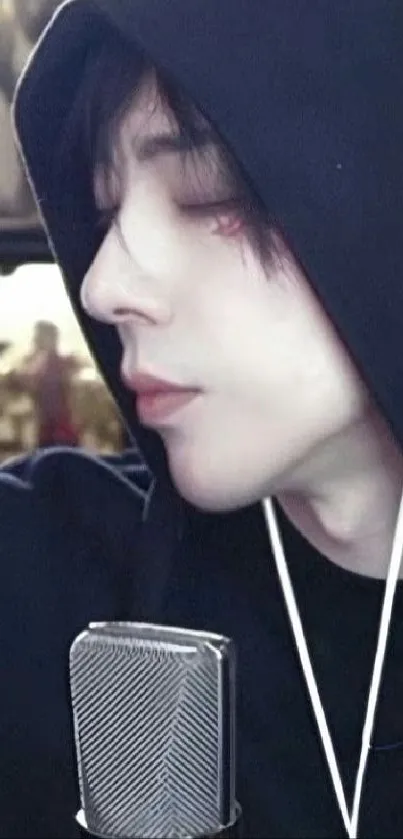 Close-up portrait of a person in a hoodie with a microphone.