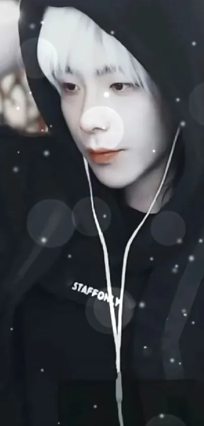 A stylish person in a black hoodie with earphones on.