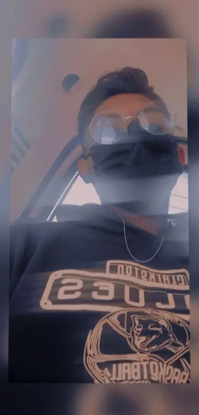 Person in a hoodie with mask and glasses on phone wallpaper.