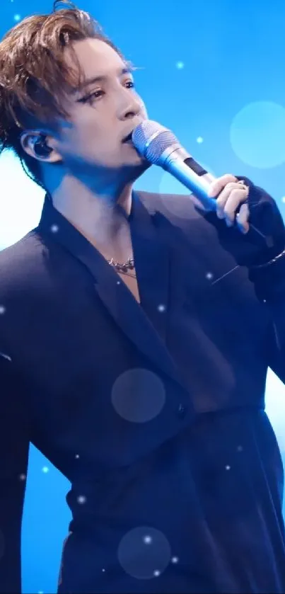 Male singer performing passionately with blue stage lighting.