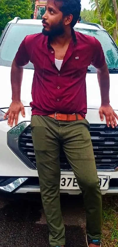 Man leaning on an SUV on a scenic road.