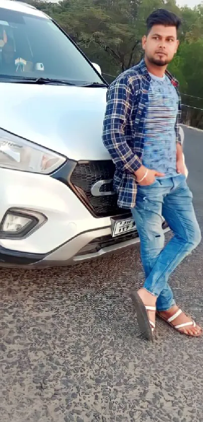 Man in casual attire leaning against a white SUV on a road.