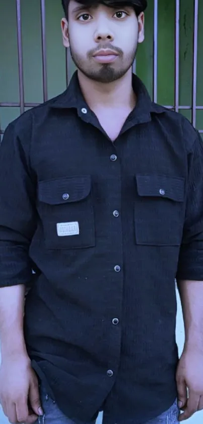 Man in a black shirt with stylish urban backdrop.