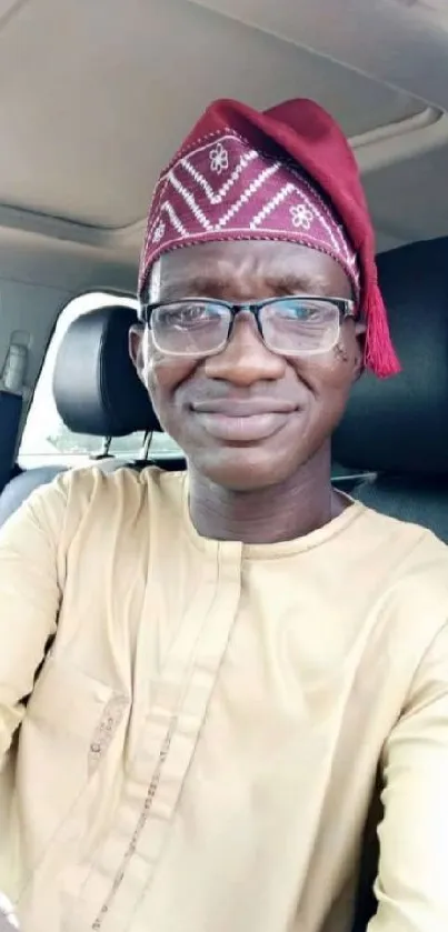 Man in a car wearing traditional attire, beige dominant color