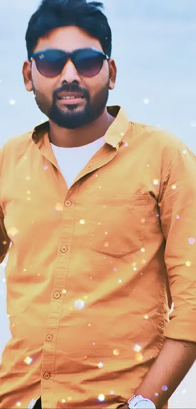 Man in yellow shirt with sunglasses on a soft sky background.