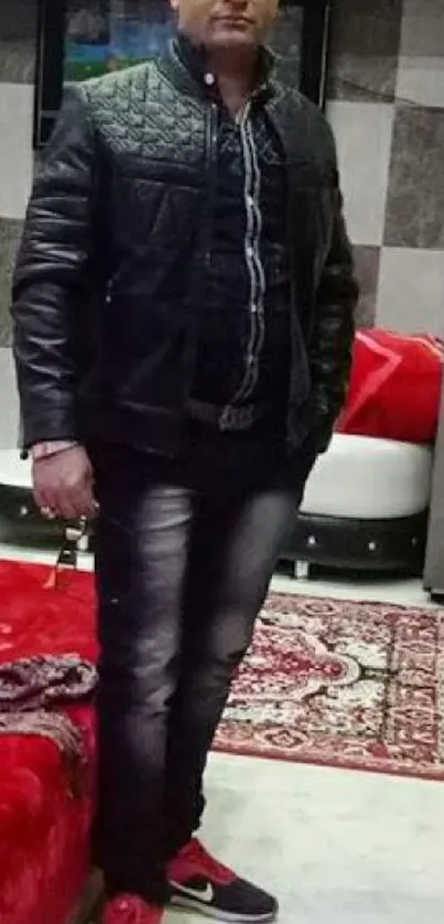 Man in black leather jacket standing in stylish room.