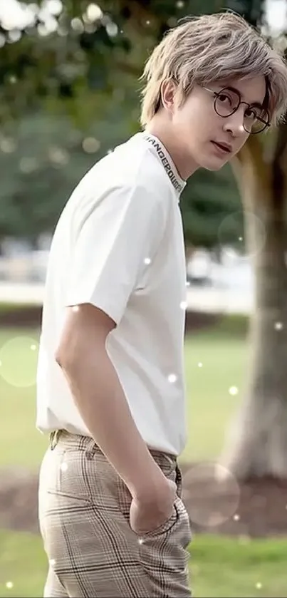 Man in glasses standing in a park.