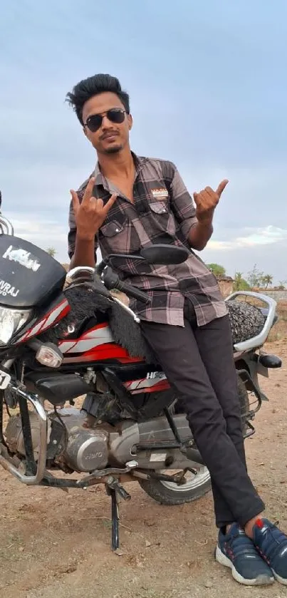 Man posing on a motorcycle against a clear sky, expressing style and adventure.