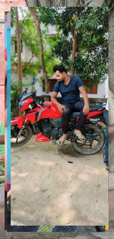 Man sitting on a vibrant red motorcycle, set in a natural outdoor setting.