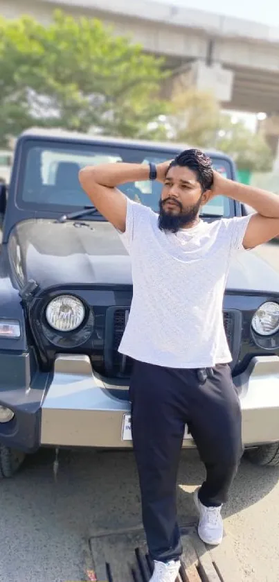 Confident man poses in front of a stylish SUV under an overpass.