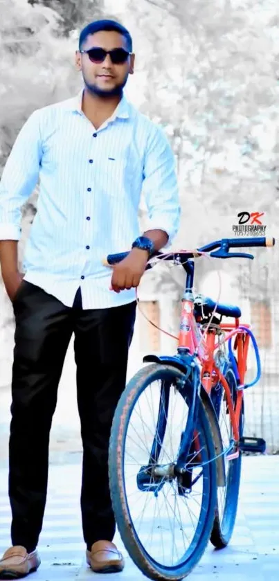 Man in sunglasses poses with orange bicycle.