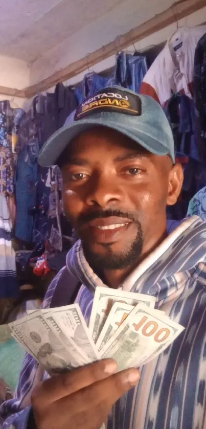 Man in stylish attire holding dollar bills in a colorful clothing store.