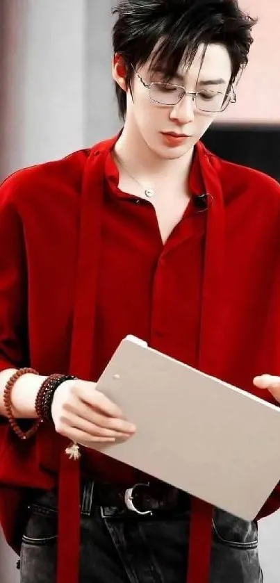 Stylish man in red shirt with book and glasses.