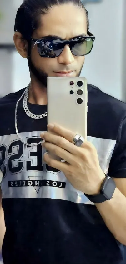 Man with sunglasses taking a selfie with a stylish smartphone.