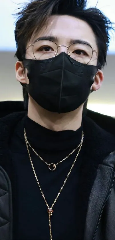 Stylish person with black mask, glasses, and gold chains.