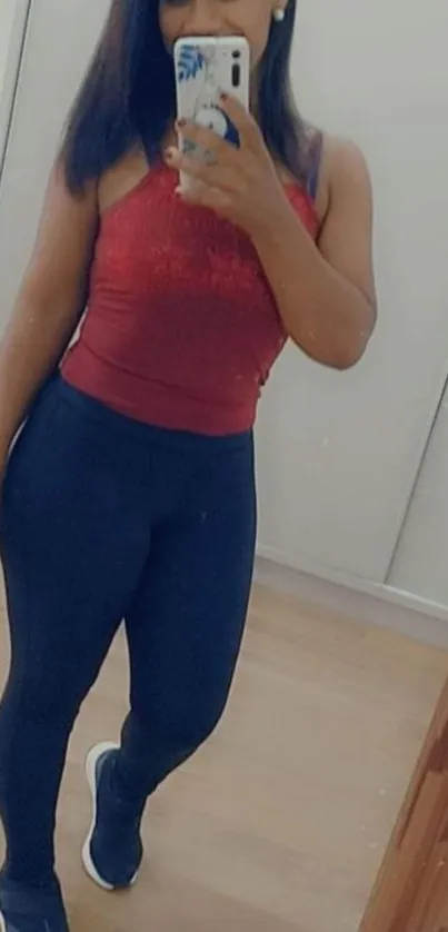 Stylish woman takes a mirror selfie in a chic outfit.