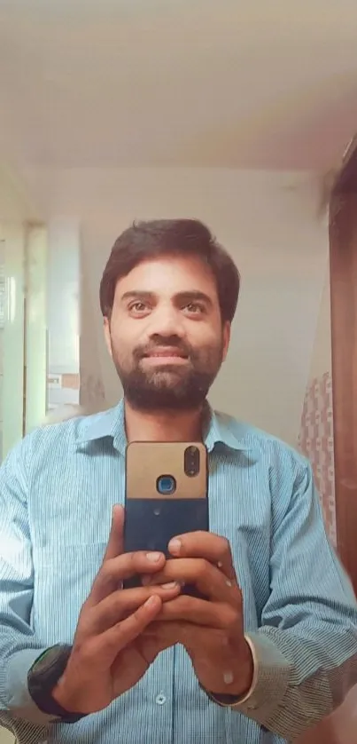 Man takes a stylish selfie in a well-lit mirror setting.