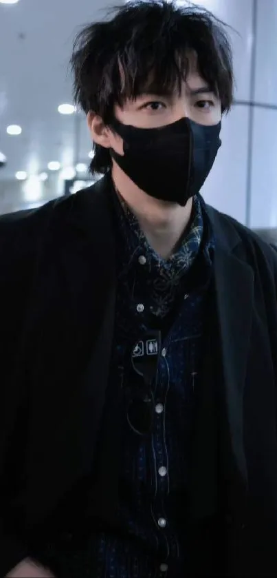 A stylish person in monochrome fashion wearing a mask, indoors.